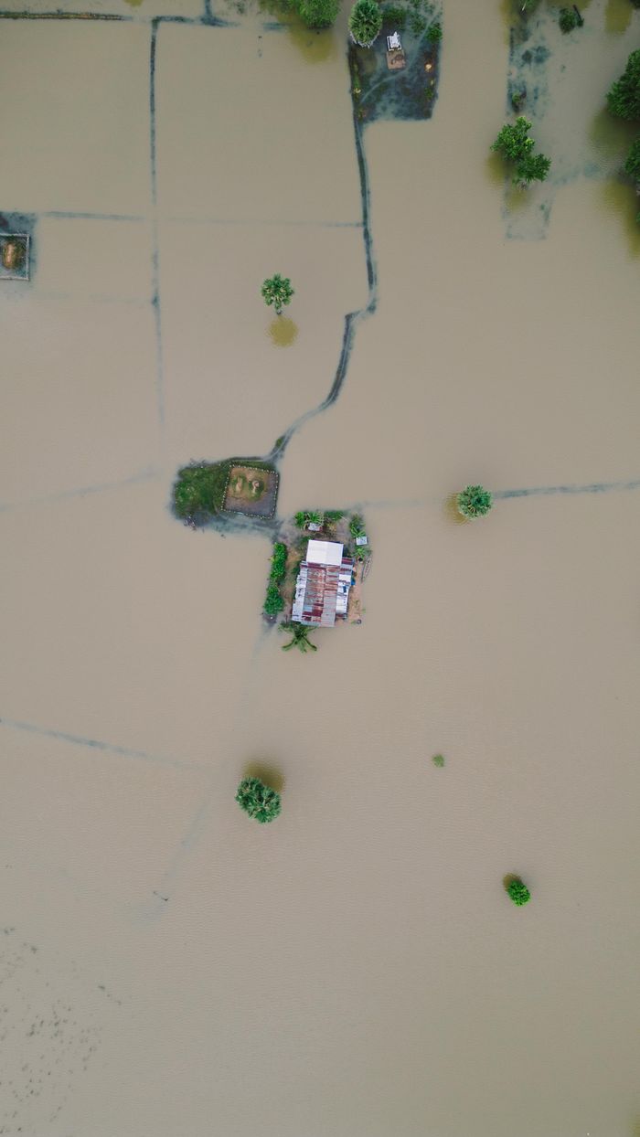 The Art of Drawing Readers In: Your attractive post title goes here Drone aerial view of inundated farm fields with a house in Krong Stueng Saen, Cambodia.
